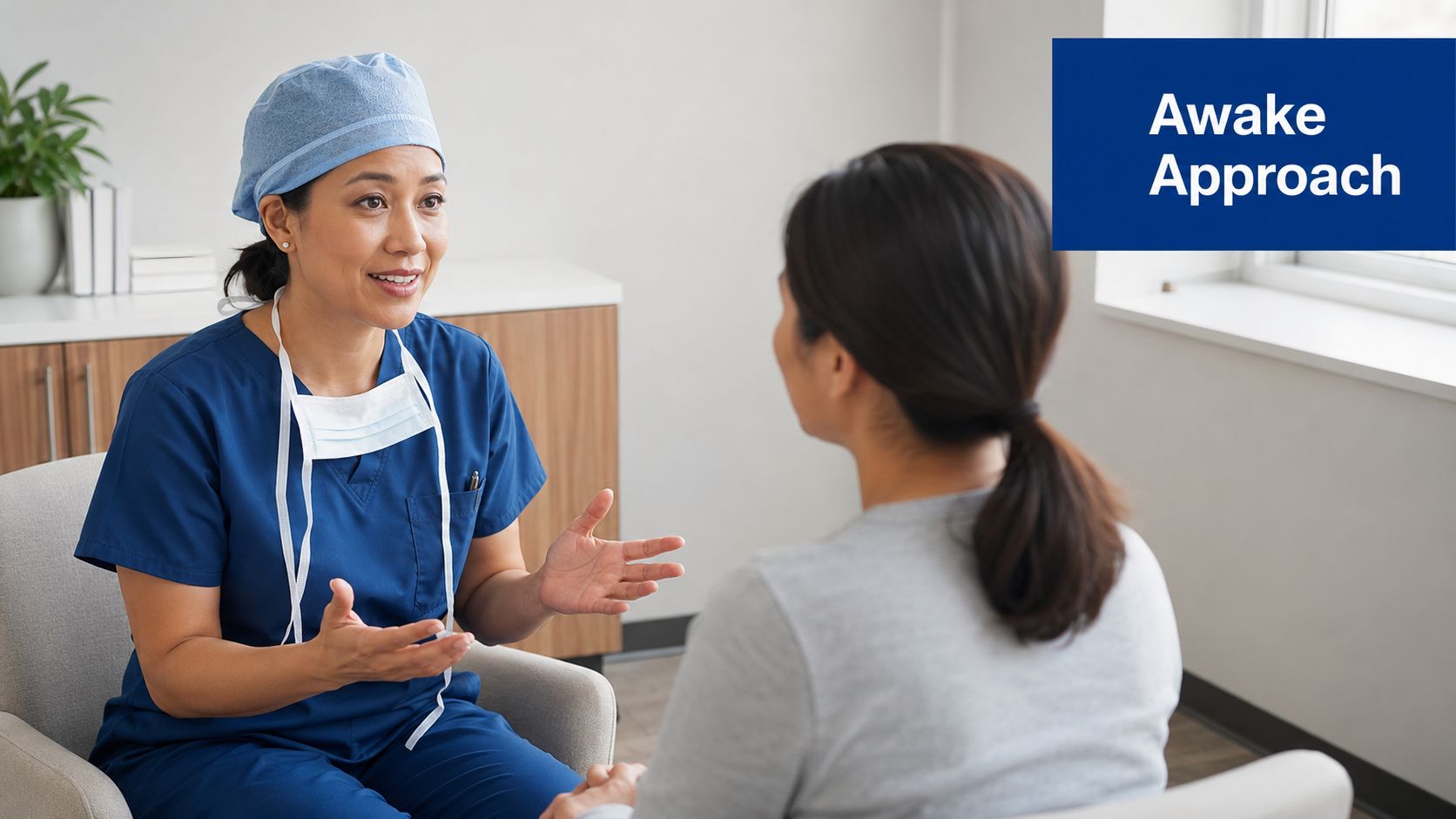 A female surgeon in blue scrubs consults with a patient about the awake approach for surgery.